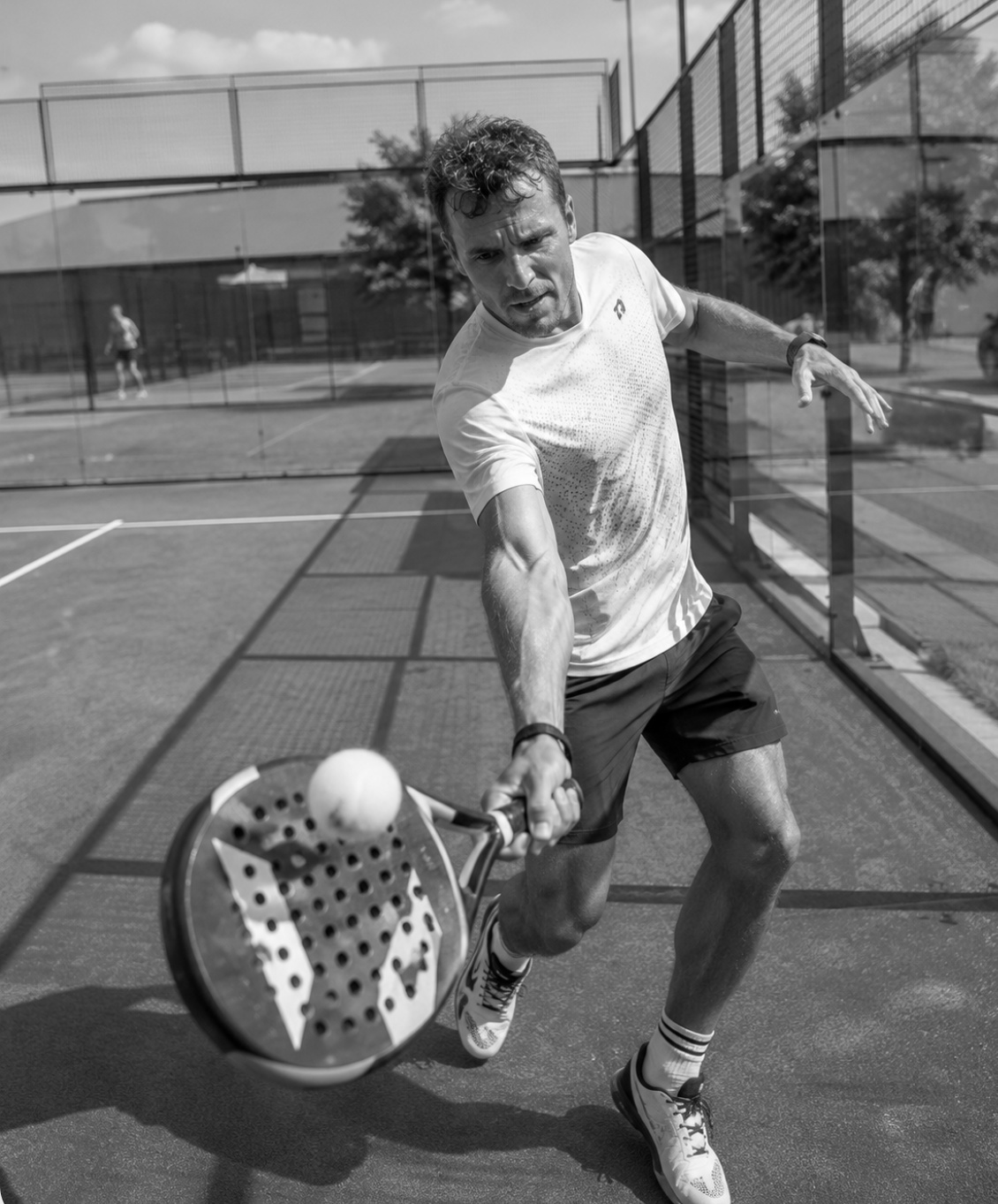 Padelspieler schlägt einen Volley auf einem Outdoor-Court
