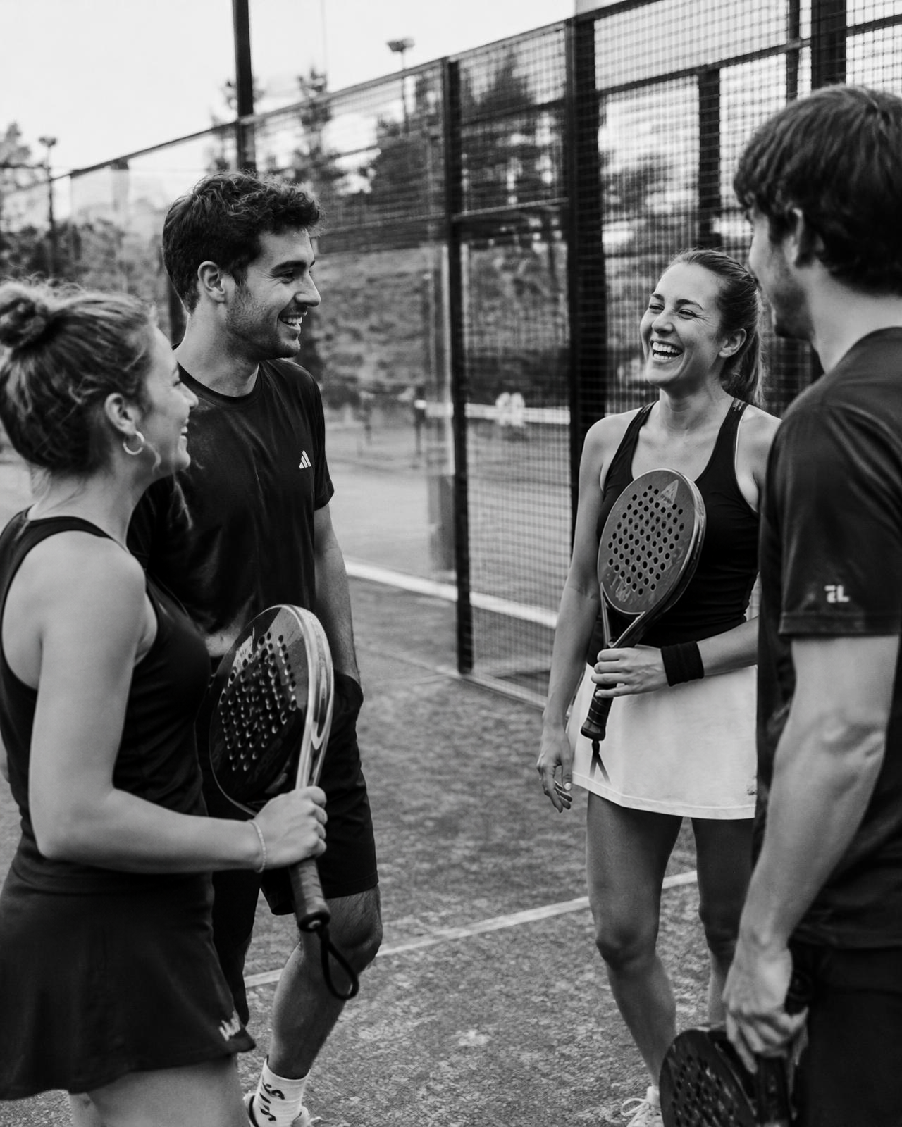 Freunde mit Padelschlägern am Court